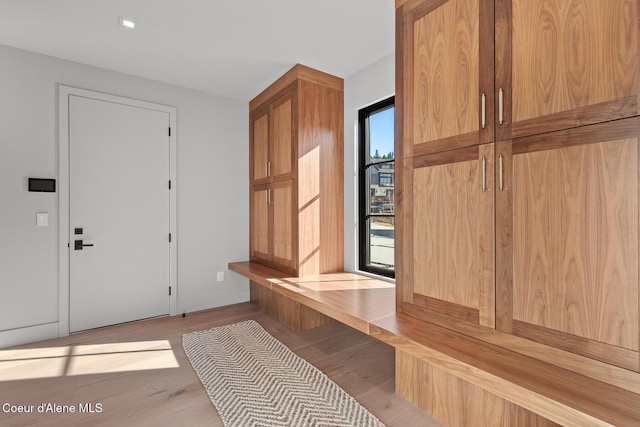 mudroom featuring light wood-style flooring and baseboards