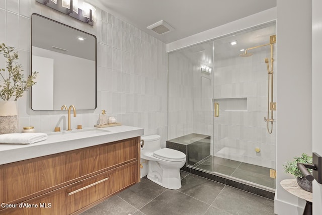 bathroom featuring tile patterned flooring, toilet, tile walls, and a shower stall