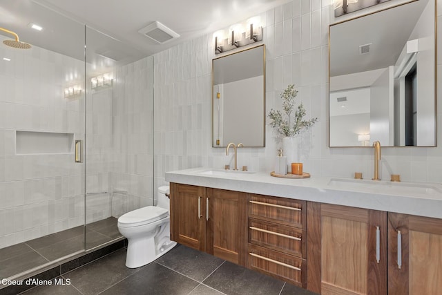 bathroom with visible vents, a shower stall, tile walls, and a sink