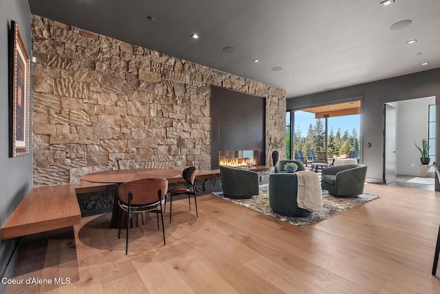 interior space featuring baseboards, a multi sided fireplace, and wood finished floors