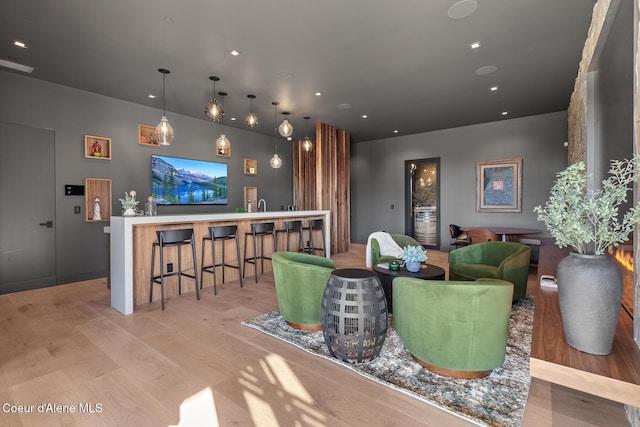 living area featuring indoor wet bar, recessed lighting, and light wood-type flooring