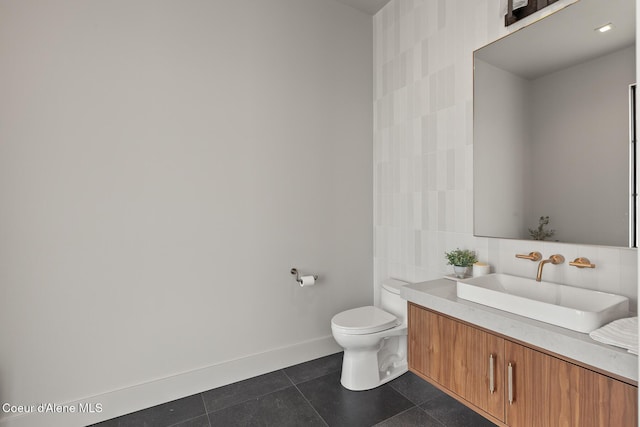 bathroom featuring baseboards, toilet, vanity, tile patterned floors, and tile walls