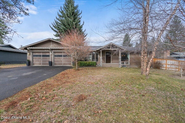 view of front of home featuring aphalt driveway, a front yard, an attached garage, and fence