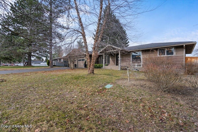 view of front of property featuring aphalt driveway and a front lawn