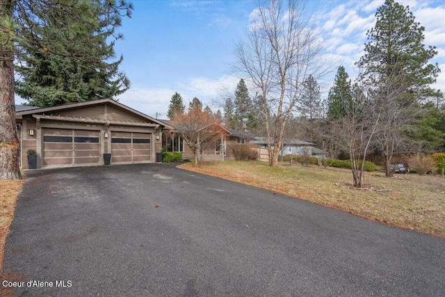 view of front facade featuring driveway, a front lawn, and an attached garage