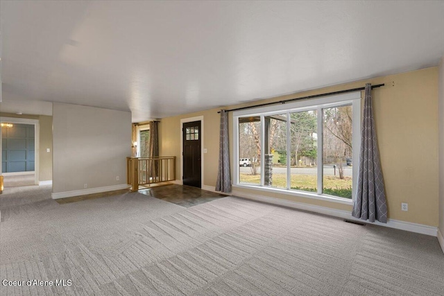 unfurnished room with visible vents, baseboards, and carpet