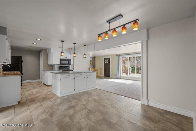 kitchen featuring a center island, electric range oven, white cabinets, black microwave, and baseboards