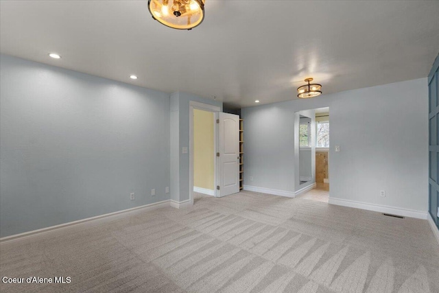 spare room with recessed lighting, baseboards, and light carpet