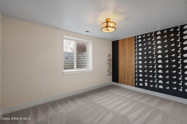 unfurnished room with visible vents, baseboards, and carpet flooring