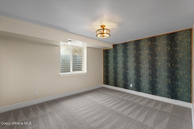 carpeted spare room featuring baseboards