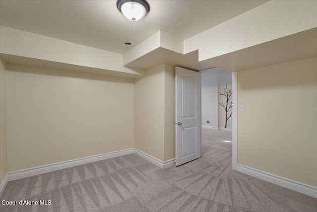 finished below grade area featuring light colored carpet and baseboards