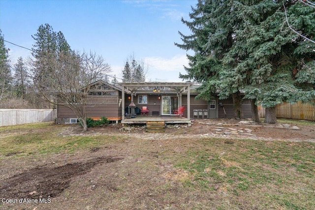 rear view of property with a deck, fence, and a pergola