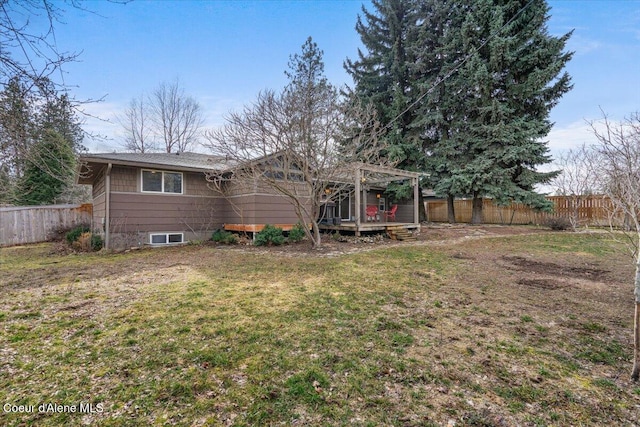 rear view of house featuring a fenced backyard, a lawn, and a wooden deck