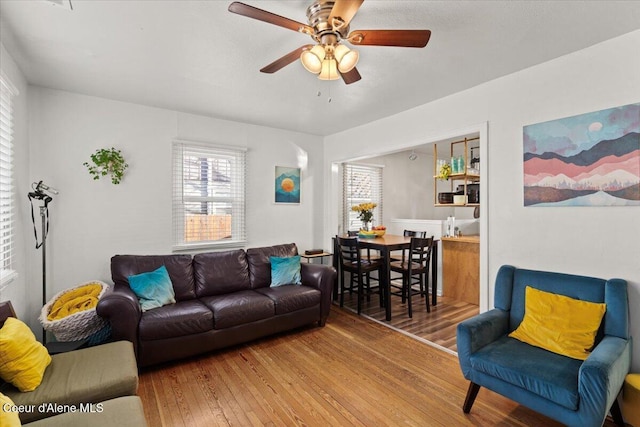 living area with ceiling fan and wood-type flooring