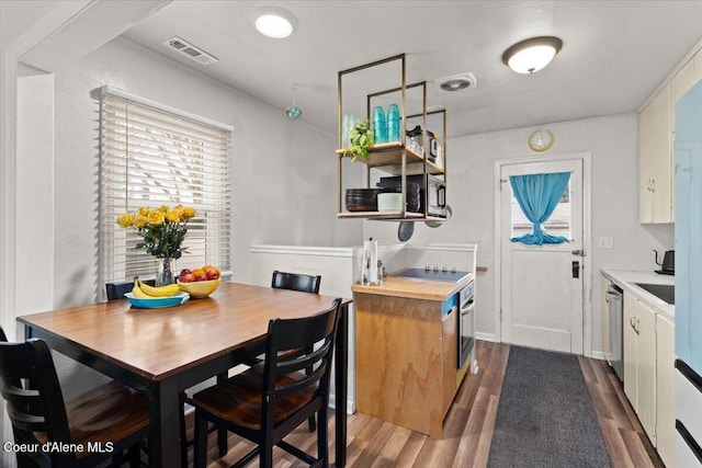 dining area featuring dark wood-type flooring and visible vents