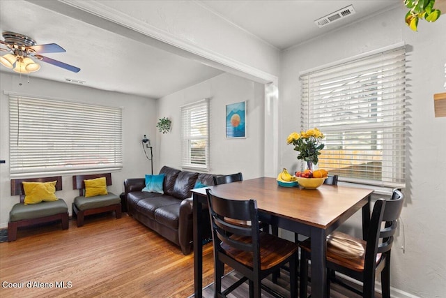 dining area featuring visible vents, light wood-style floors, and a ceiling fan