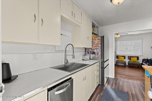 kitchen with a sink, dark wood-style floors, white cabinetry, appliances with stainless steel finishes, and light countertops