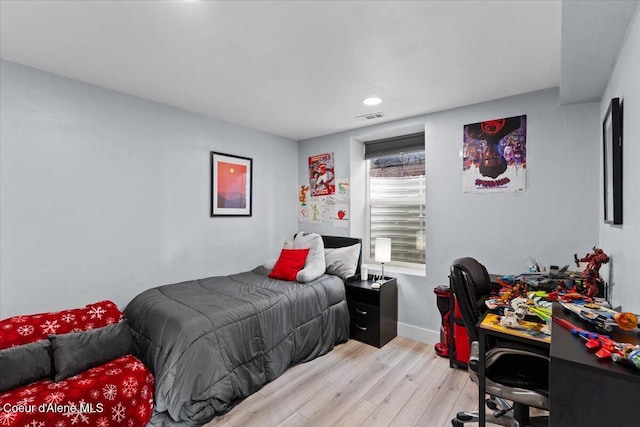 bedroom featuring light wood finished floors, visible vents, and baseboards