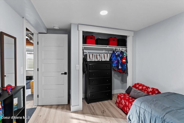 bedroom featuring wood finished floors, a closet, and baseboards