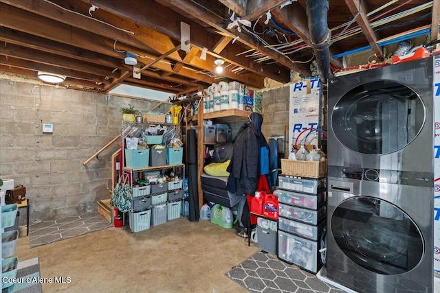 unfinished below grade area with stacked washer / drying machine