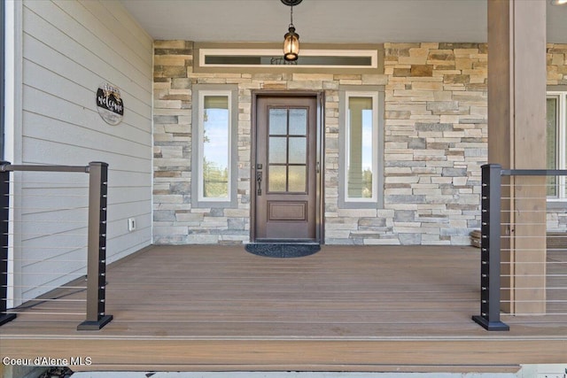 entrance to property with stone siding and a porch