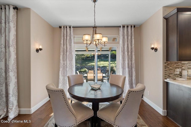 dining area with a chandelier, baseboards, and dark wood-style floors