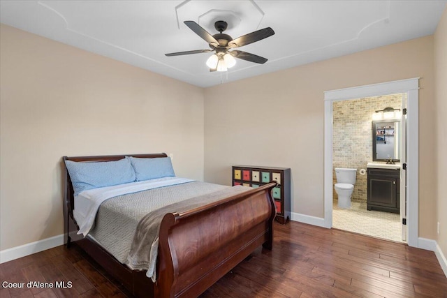 bedroom featuring baseboards, wood-type flooring, and connected bathroom