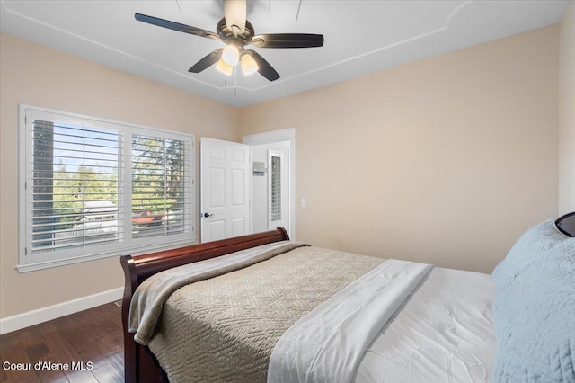 bedroom with dark wood finished floors, a ceiling fan, and baseboards