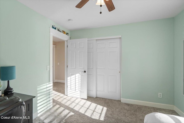 bedroom with a closet, baseboards, carpet, and a ceiling fan