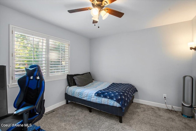 carpeted bedroom with visible vents, baseboards, and a ceiling fan