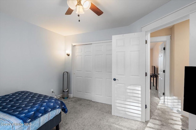 carpeted bedroom with a closet and a ceiling fan