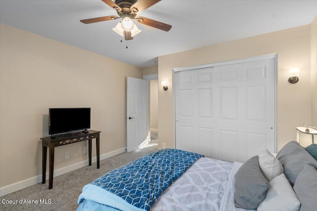 bedroom with a closet, baseboards, carpet floors, and ceiling fan