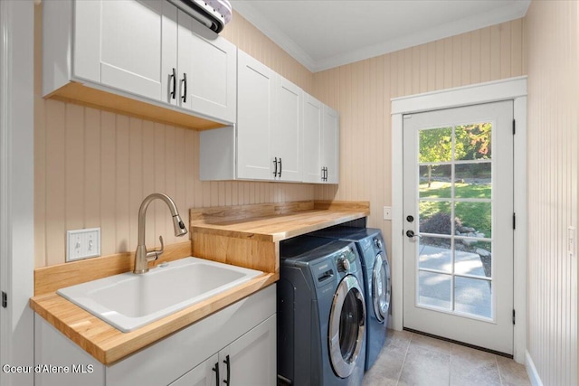 laundry room with light tile patterned floors, cabinet space, ornamental molding, a sink, and independent washer and dryer