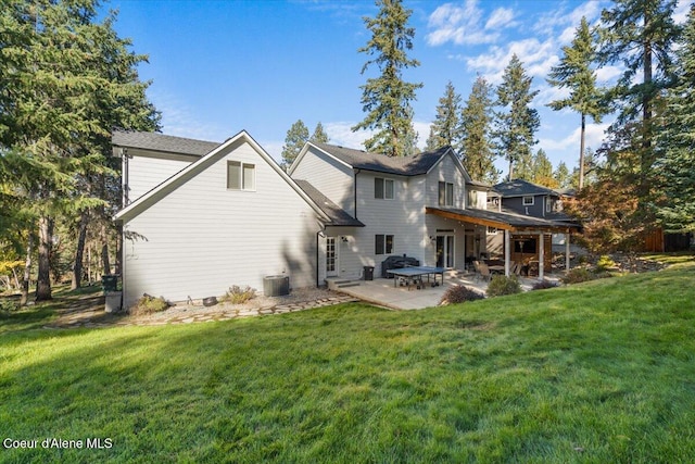 rear view of house featuring a patio, a yard, and cooling unit