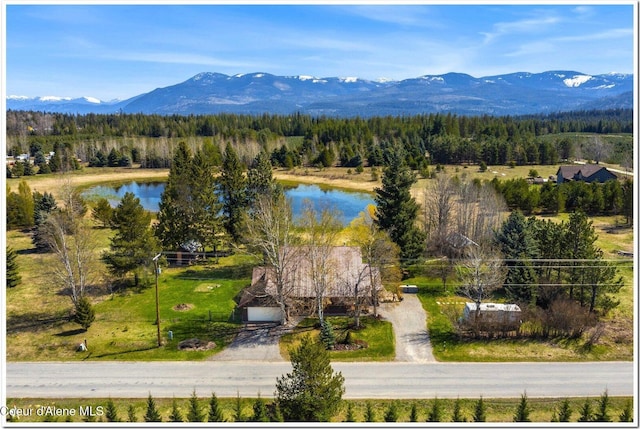 birds eye view of property with a view of trees and a water and mountain view