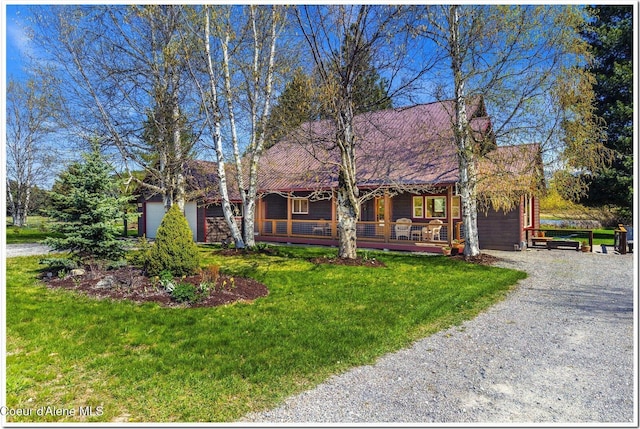 view of front of home with a porch, driveway, and a front lawn