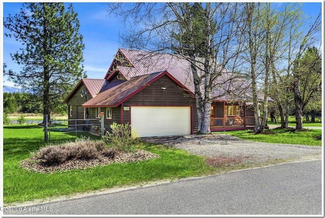view of front facade featuring a porch, metal roof, dirt driveway, a front lawn, and an attached garage