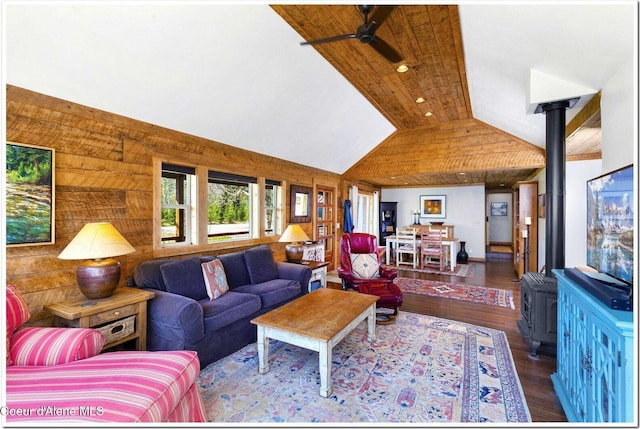 living room with a wood stove, a ceiling fan, recessed lighting, wood finished floors, and vaulted ceiling
