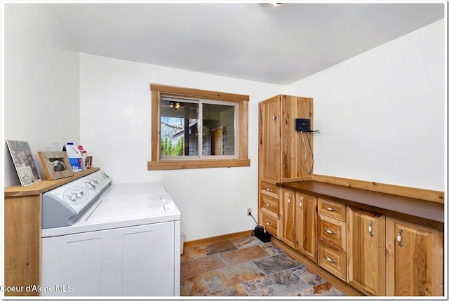 washroom with baseboards, laundry area, washing machine and dryer, and stone finish flooring