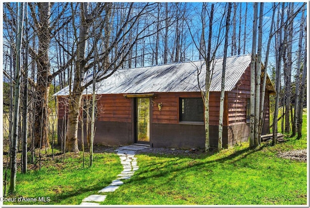 view of front of property featuring metal roof and a front yard