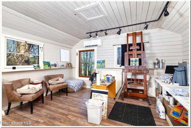 miscellaneous room with a wall mounted AC, rail lighting, and wood finished floors