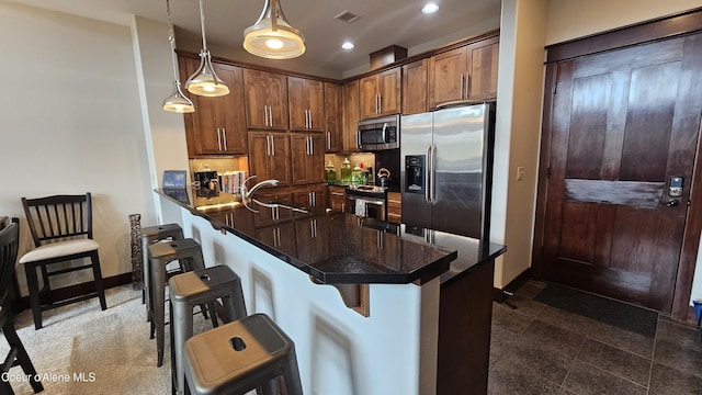 kitchen featuring visible vents, recessed lighting, a kitchen breakfast bar, stainless steel appliances, and a sink