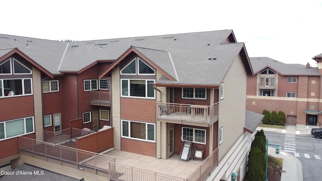 back of house with roof with shingles