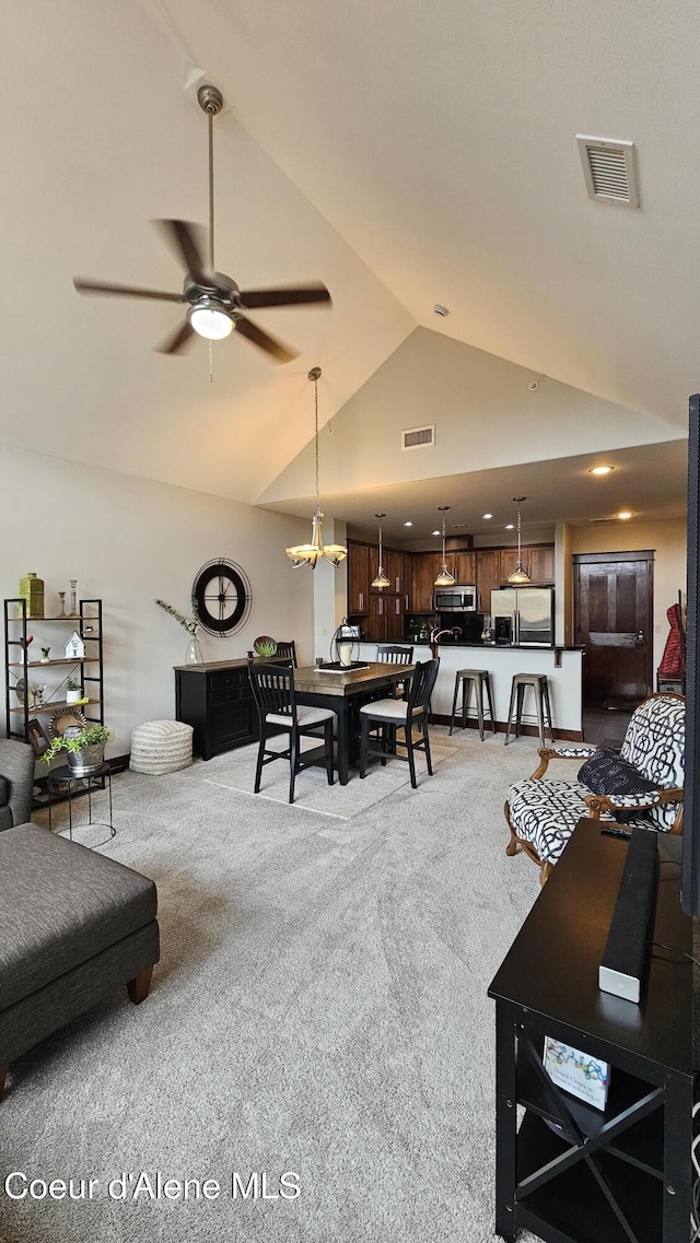 living area featuring visible vents, carpet floors, high vaulted ceiling, and ceiling fan