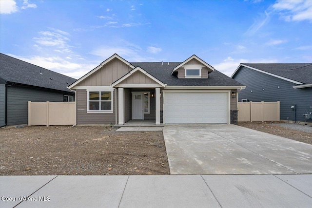 view of front of property with a shingled roof, an attached garage, concrete driveway, and fence