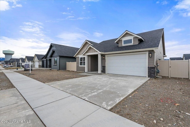 view of front of home with a gate, stone siding, fence, roof with shingles, and concrete driveway