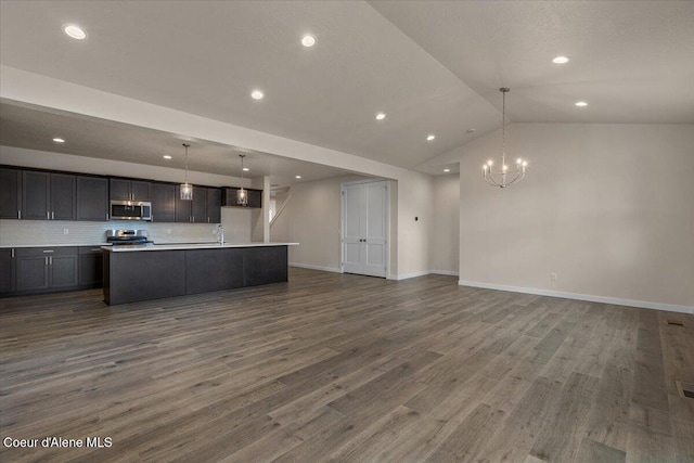 kitchen with dark wood-style floors, open floor plan, appliances with stainless steel finishes, light countertops, and vaulted ceiling