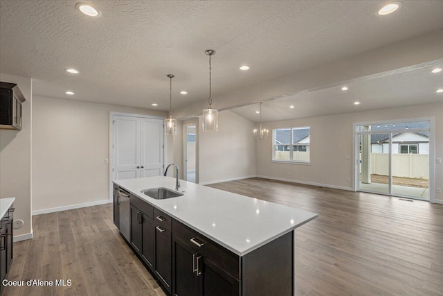 kitchen featuring a textured ceiling, light countertops, wood finished floors, and a sink