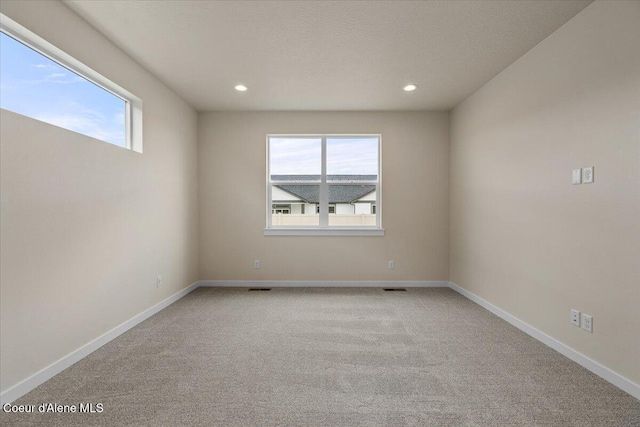 unfurnished room featuring recessed lighting, baseboards, a healthy amount of sunlight, and light carpet