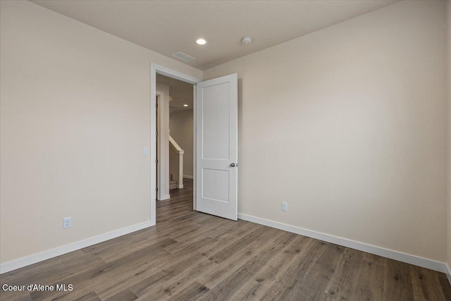 spare room featuring visible vents, recessed lighting, baseboards, and wood finished floors